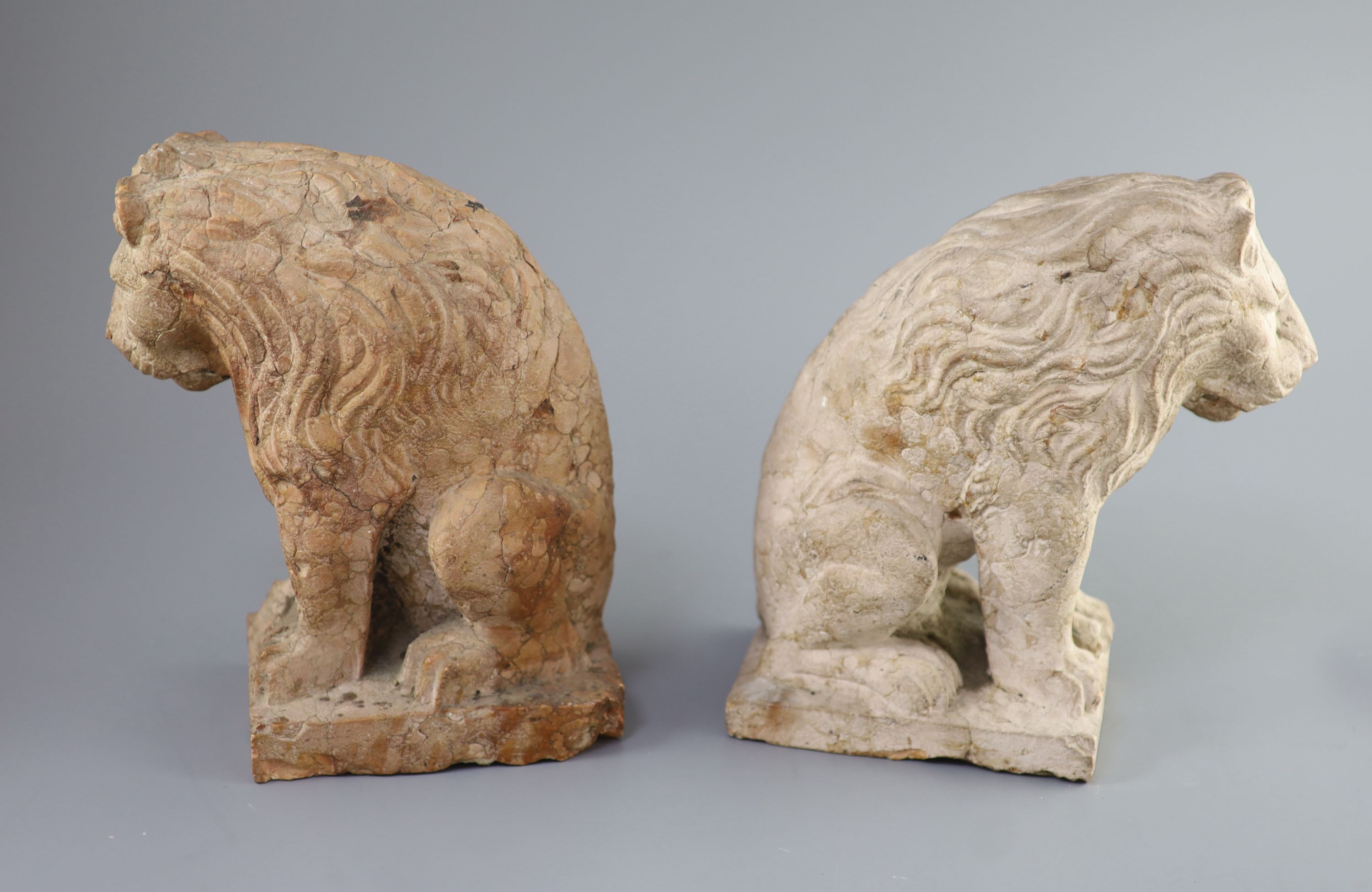 A pair of European pink marble seated lions, 18th century or earlier, 25cm high